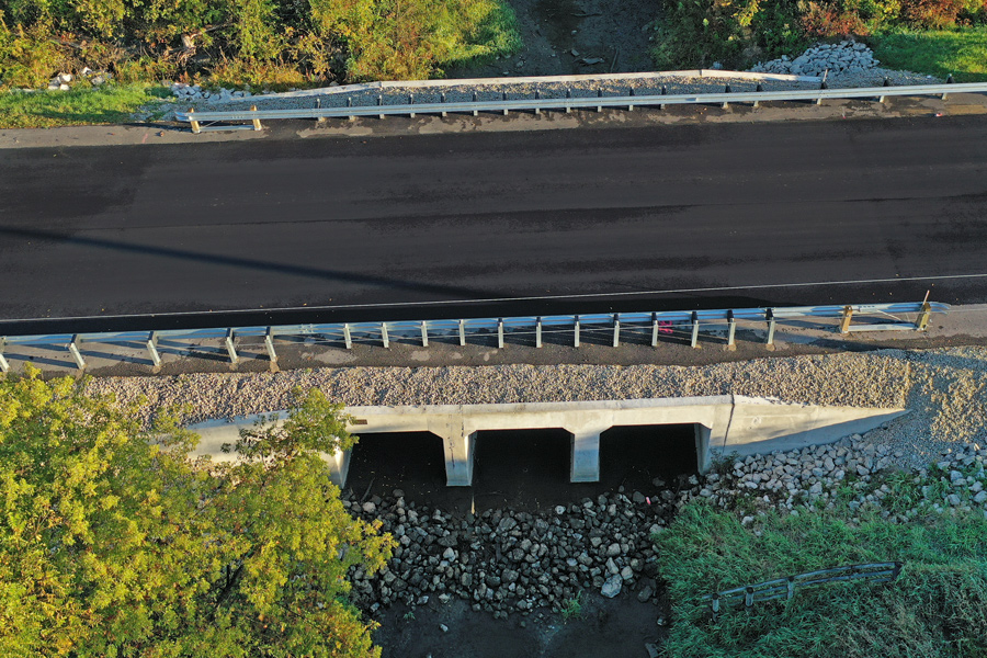 Edwards-DJI_0741 Aerial view of a newly constructed concrete culvert beneath a road, surrounded by landscaped greenery and gravel.