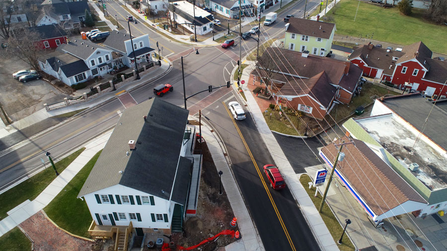 DJI_0012-Web Aerial view of a suburban intersection showcasing municipal improvements, with newly paved roads and residential buildings nearby.