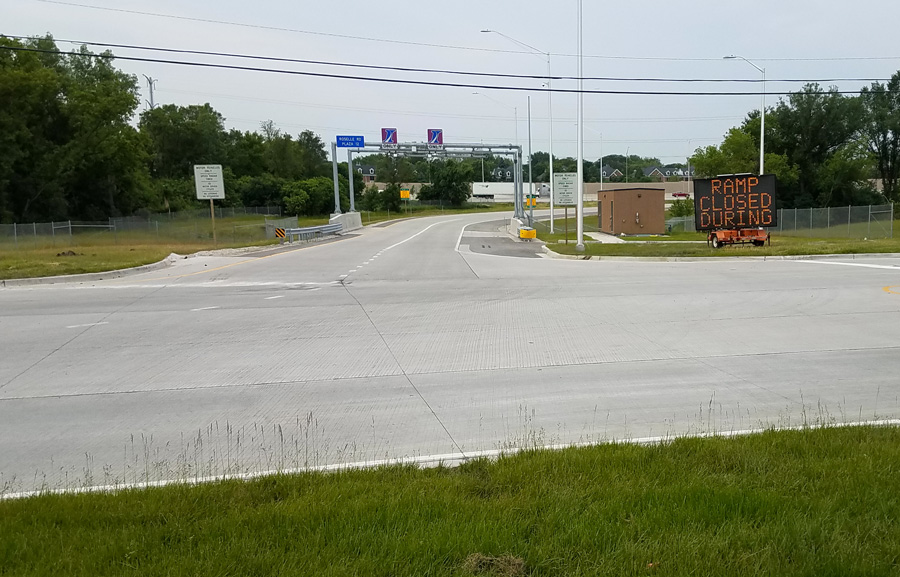 Central-Rd-ISTHA-20190619_070403_web A view of a closed ramp with a construction sign, flanked by green grass and trees, indicating municipal road improvements.