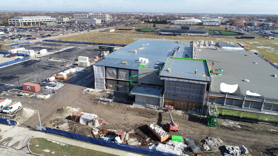 CommunityIceCtr-DJI_0020_web Aerial view of a construction site featuring a new building under development, surrounded by construction materials and machinery.