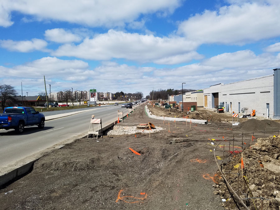 Mellody-VH-Rds_141658_web Construction site along a busy road, featuring ongoing infrastructure improvements, utility work, and visible signage.