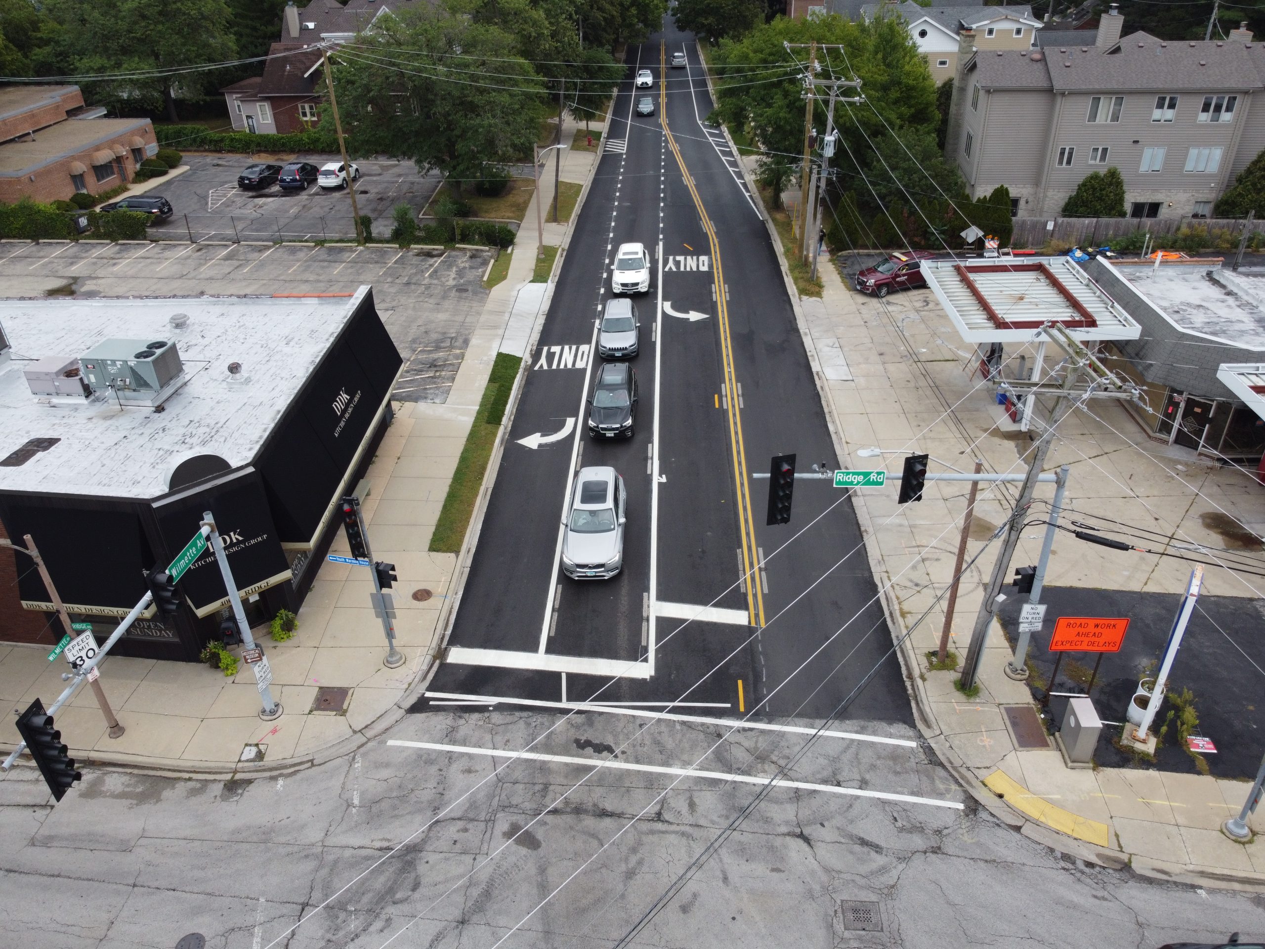 DCIM101MEDIADJI_0566.JPG Aerial view of a city intersection showcasing newly marked lanes, traffic signals, and surrounding commercial buildings.